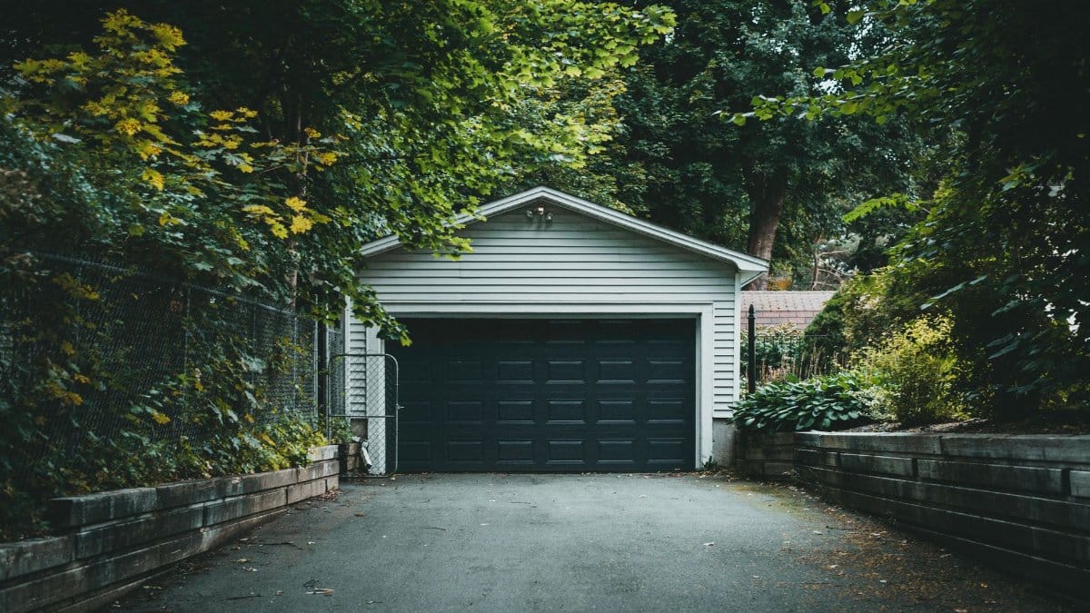A scenic garage with lush greenery and a driveway, perfect for residential and nature-themed content.