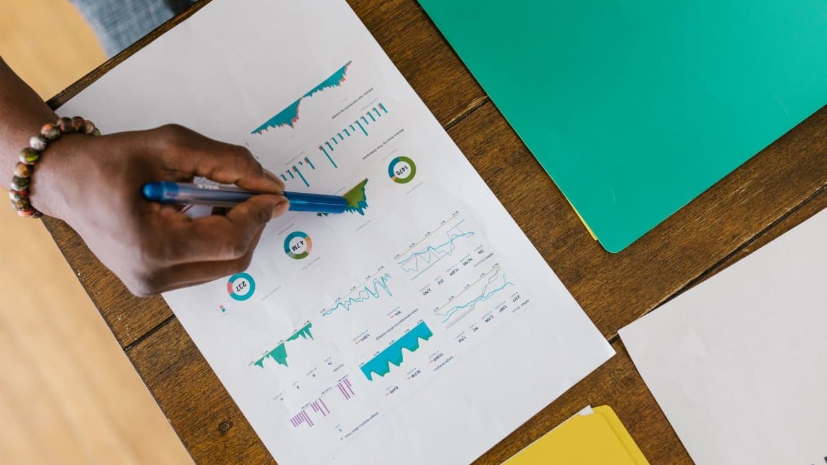 Overhead view of a person analyzing business charts and graphs on paper.