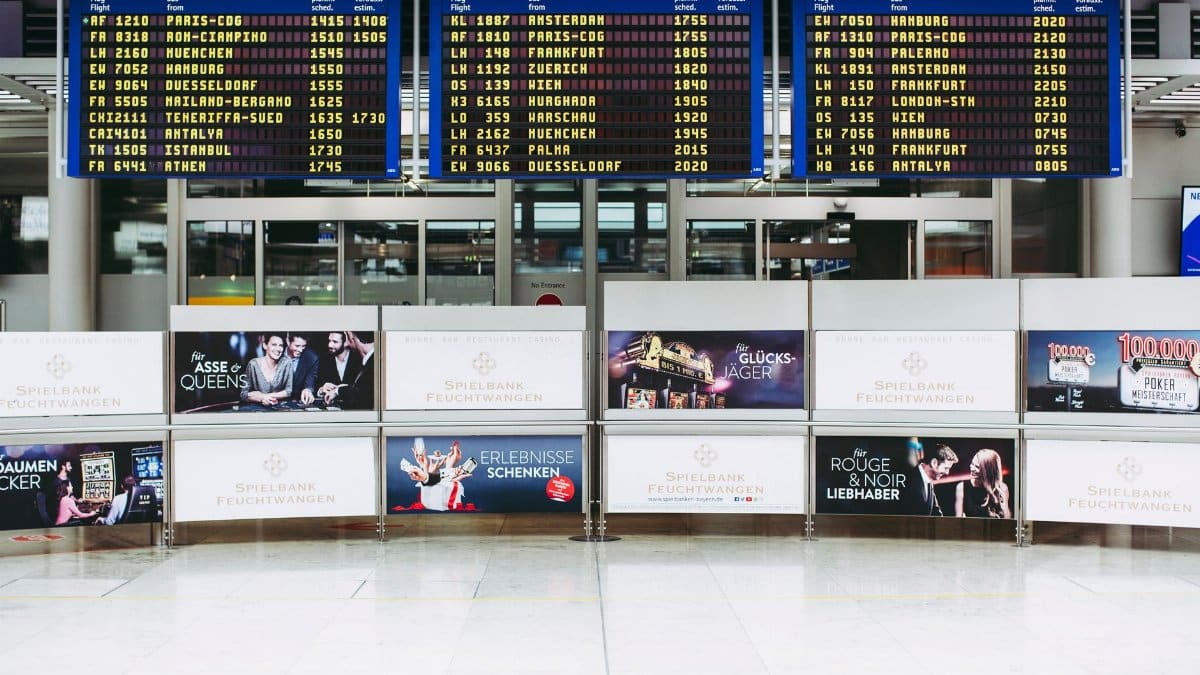 Electronic displays showing flight arrivals at Nuremberg Airport terminal.