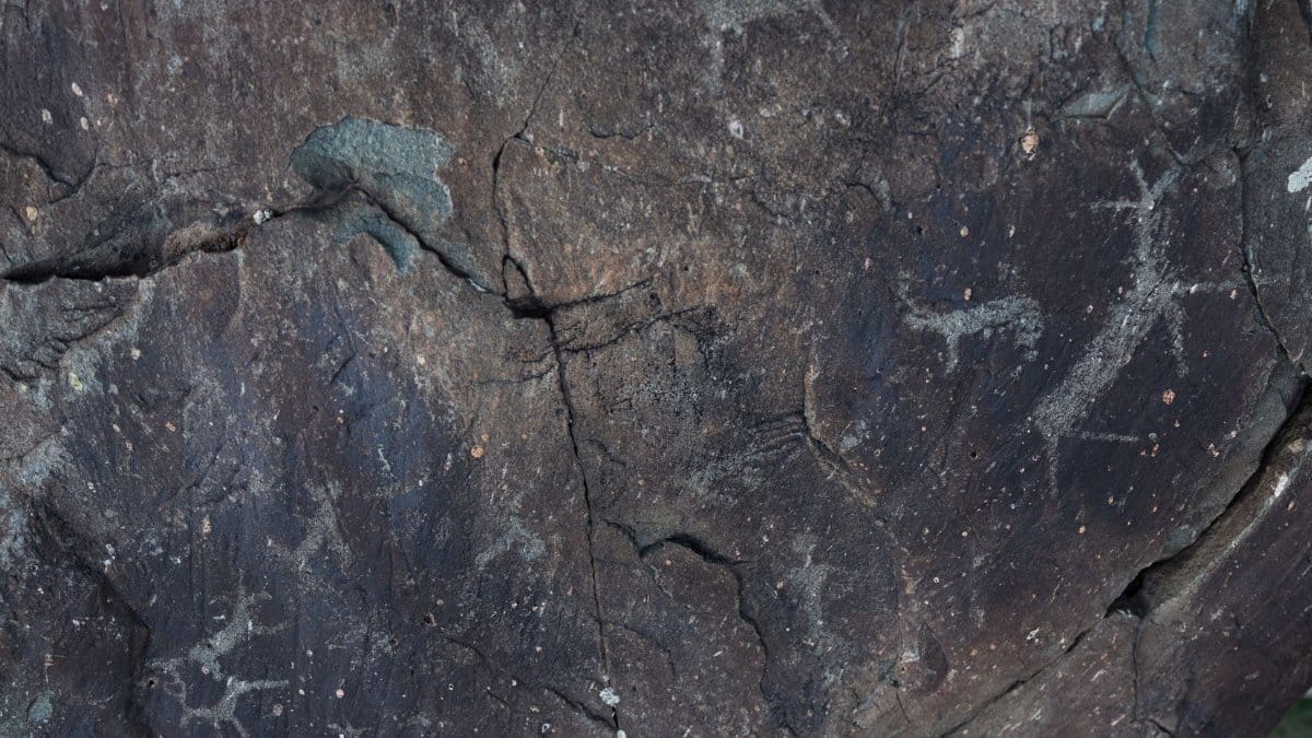 From above of dark gray natural slope with shabby surface and tiny aged paintings