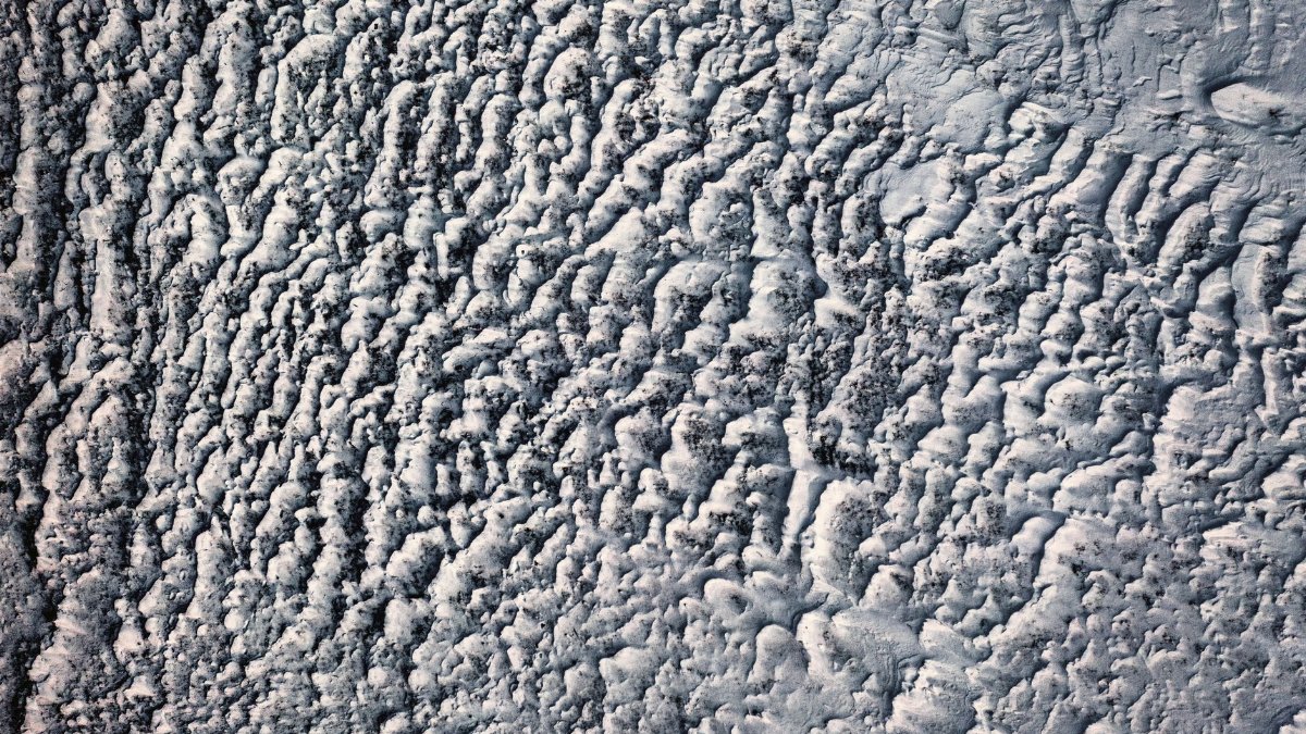 Aerial view of a textured snowy landscape in Minnesota during winter, creating abstract patterns.