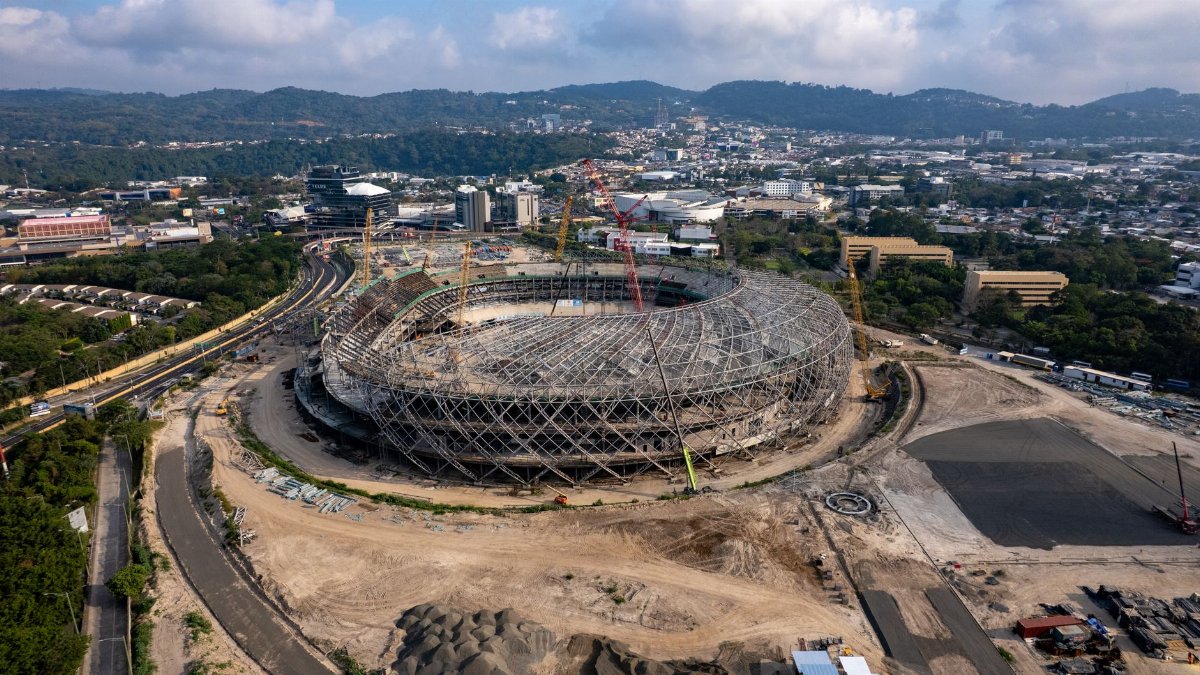 An aerial shot capturing the extensive construction of a stadium amidst a bustling urban landscape.