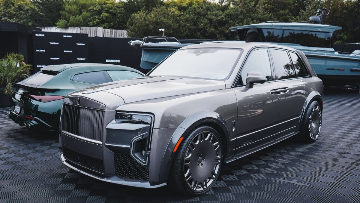 Sleek silver SUV showcased at an outdoor luxury car event with other premium vehicles.
