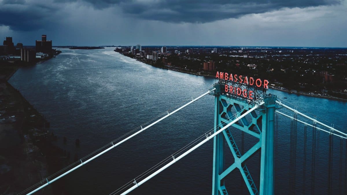 Stunning aerial image of Ambassador Bridge in Detroit under a dramatic sky.