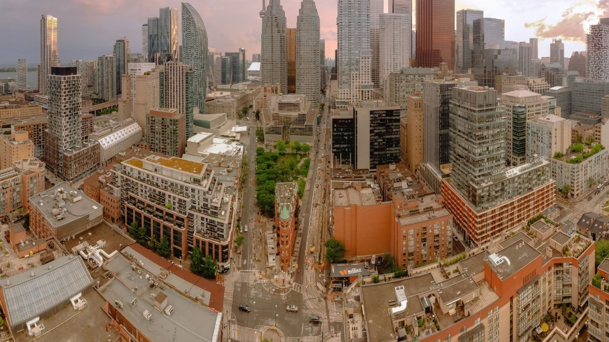 Skyline of a modern city captured from above, showcasing skyscrapers and urban streets.