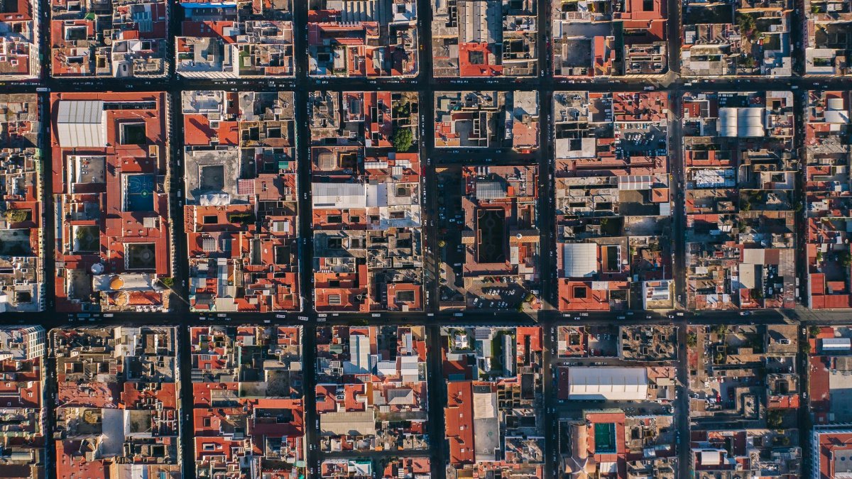 Drone aerial view capturing the intricate urban grid of Puebla, Mexico with vibrant rooftops.