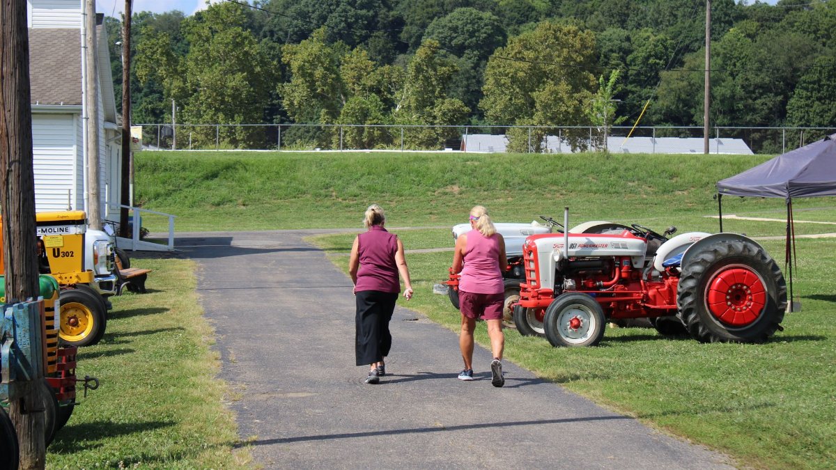 Two women walk past vintage tractors at a show in Lancaster, Ohio.