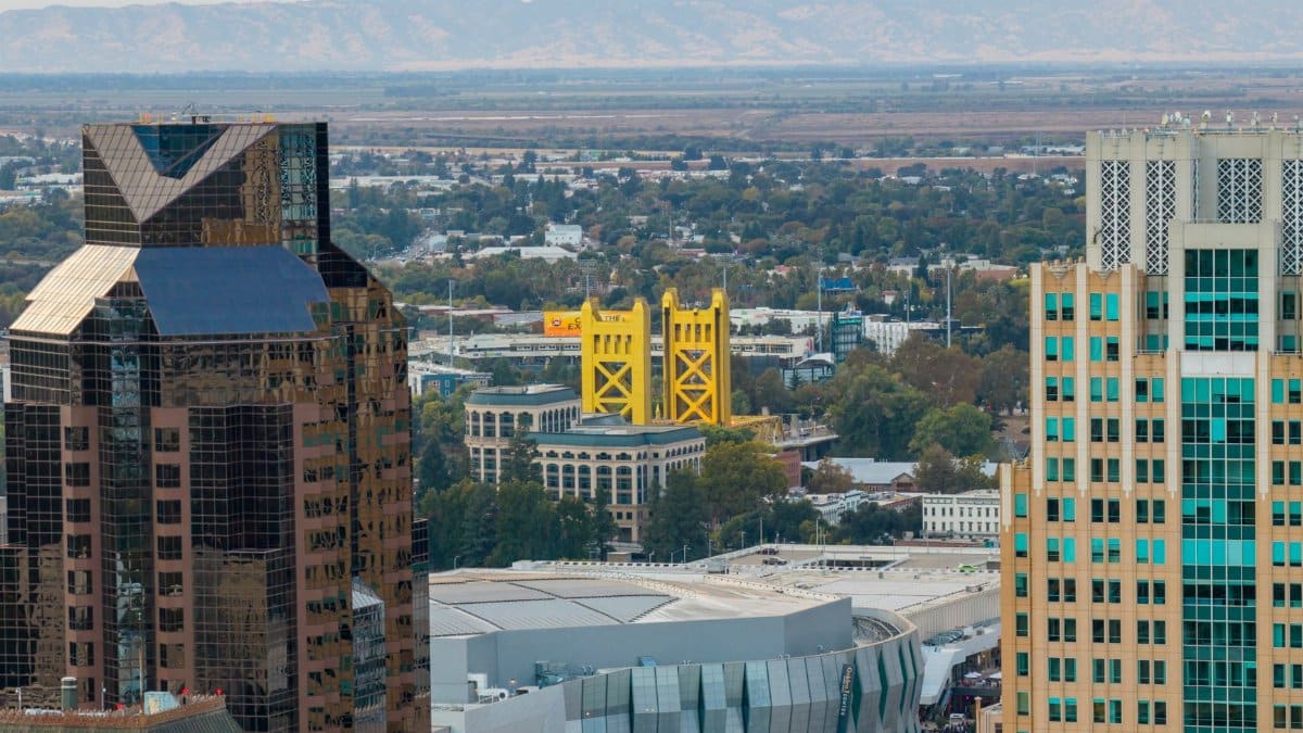 Stunning aerial view of Sacramento featuring the iconic yellow Tower Bridge surrounded by modern buildings.