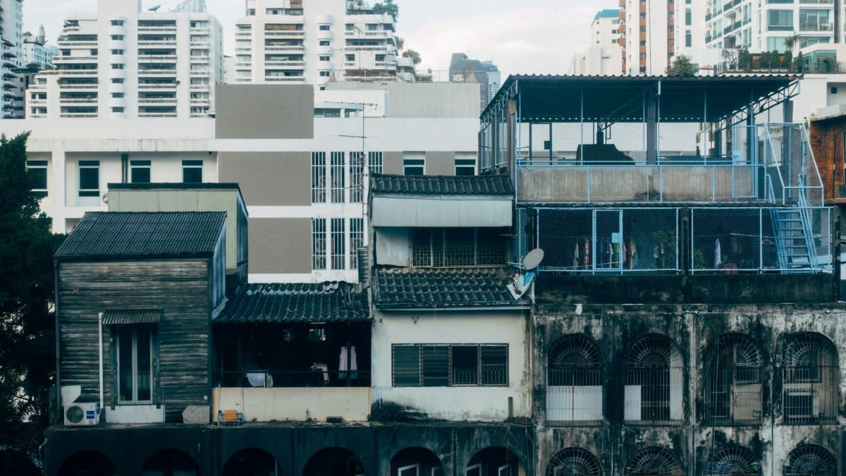 A juxtaposition of aging and modern urban buildings in a dense city landscape.