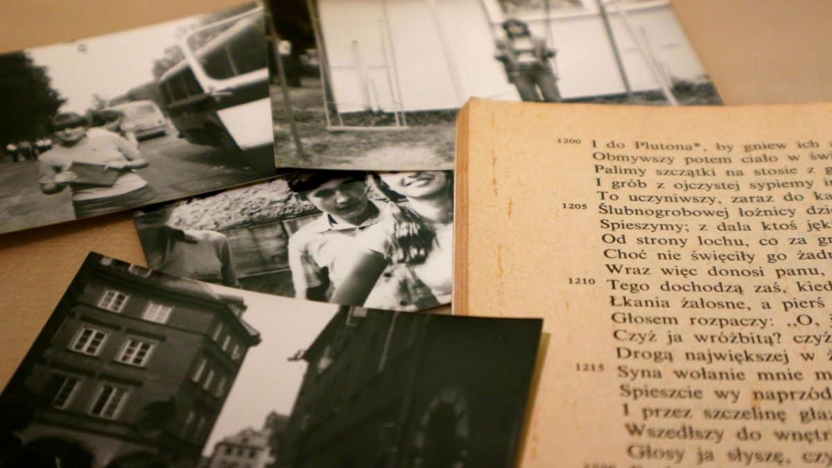 Close-up of vintage black and white photographs with an open book showcasing text.