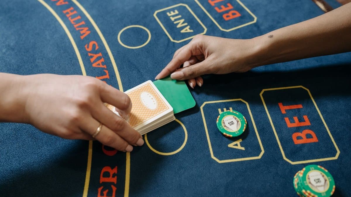 Intimate view of poker game in a casino with two hands exchanging cards on the table.