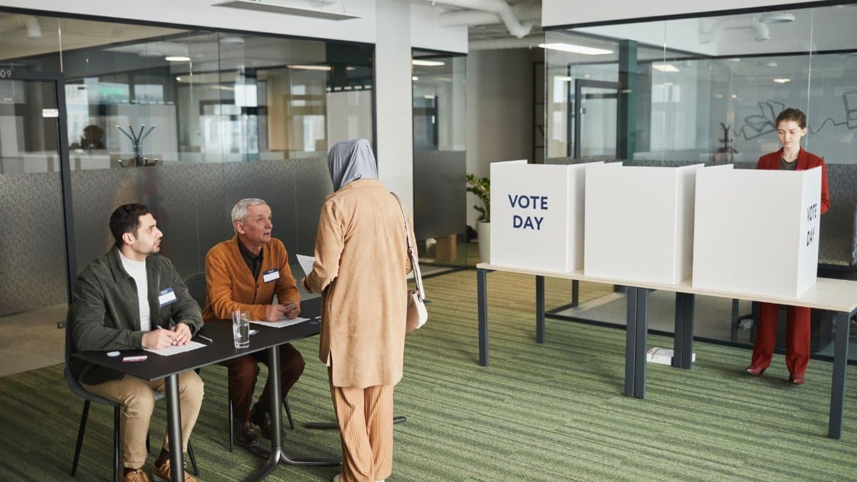 A diverse group of people in an office setting participating in election day activities.