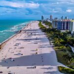 Aerial shot of Miami Beach showcasing the coastline, city skyline, and vibrant sea.