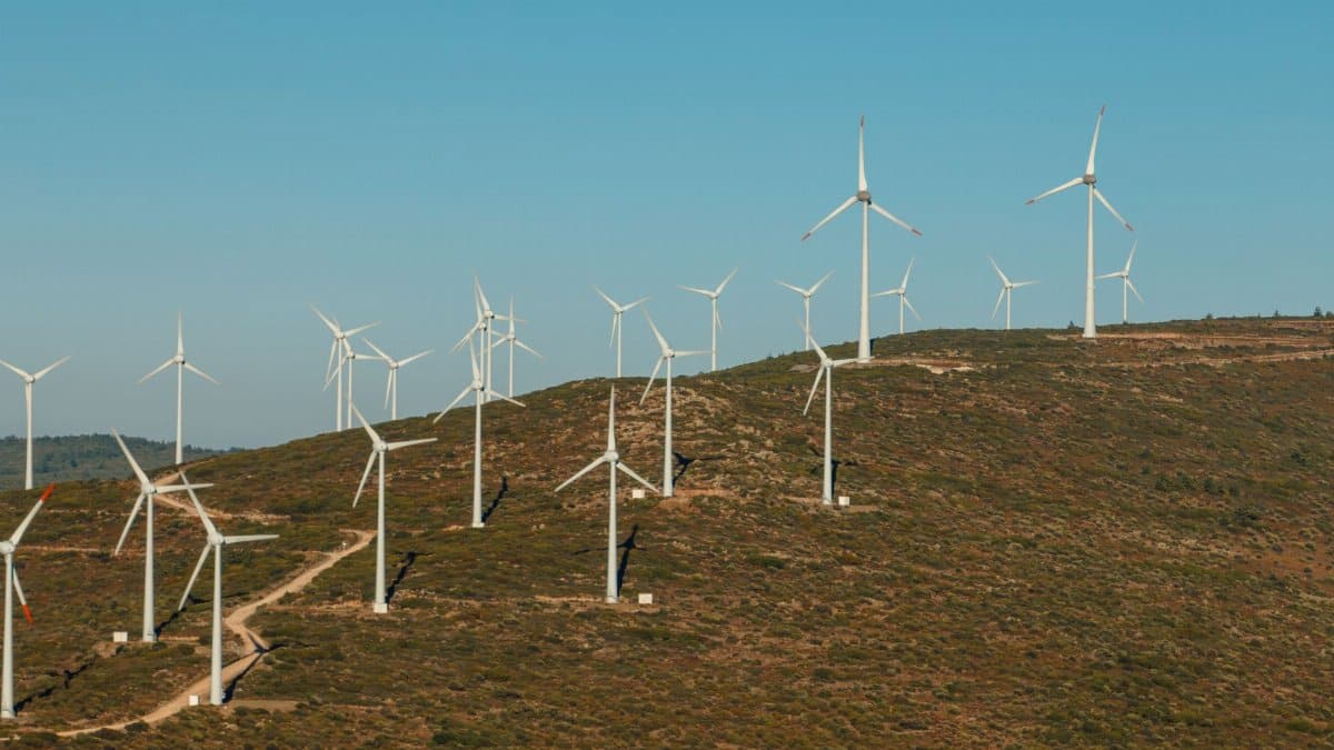 A scenic view of wind turbines on a hill in Çeşme, İzmir, showcasing renewable energy in a rural area.