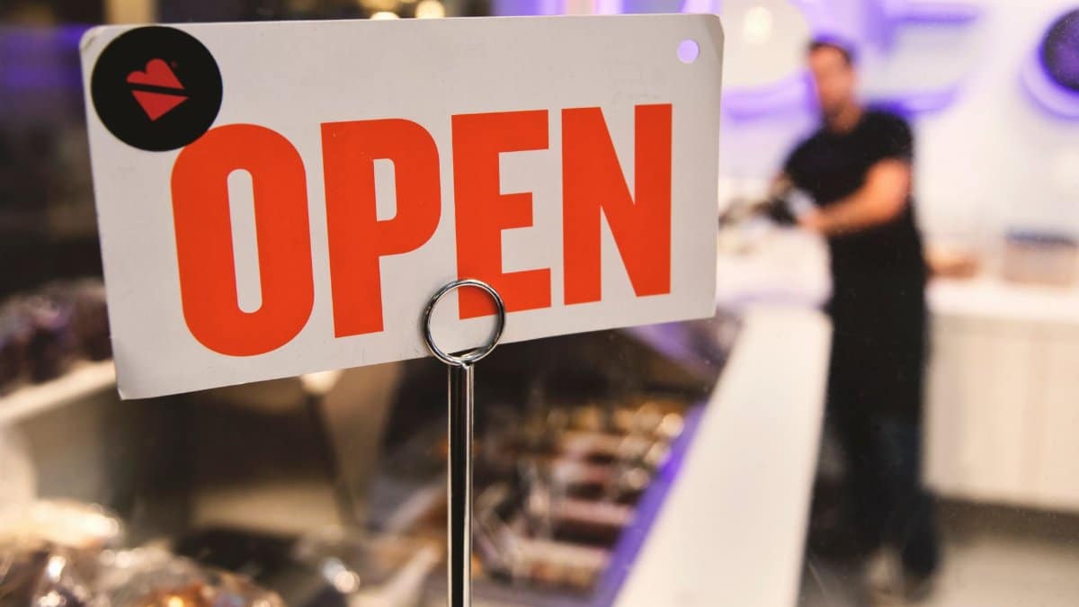 A vibrant open sign in a Los Angeles shop with a blurred figure in the background.