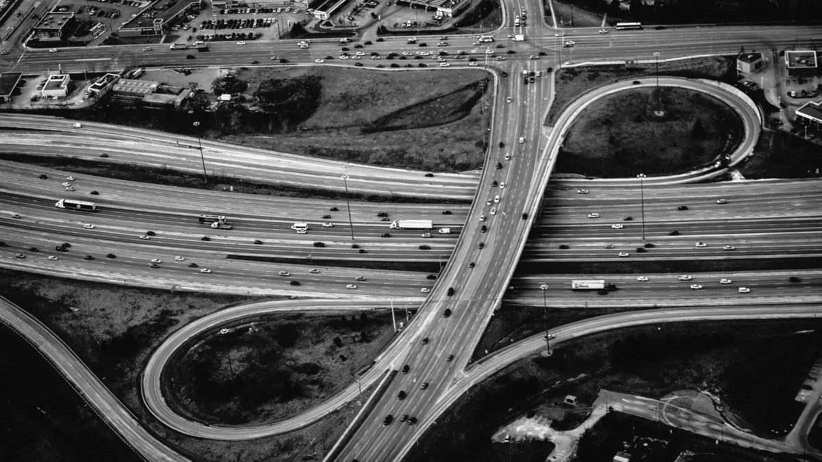 High-angle shot of a complex urban highway intersection in black and white, showcasing modern transportation.