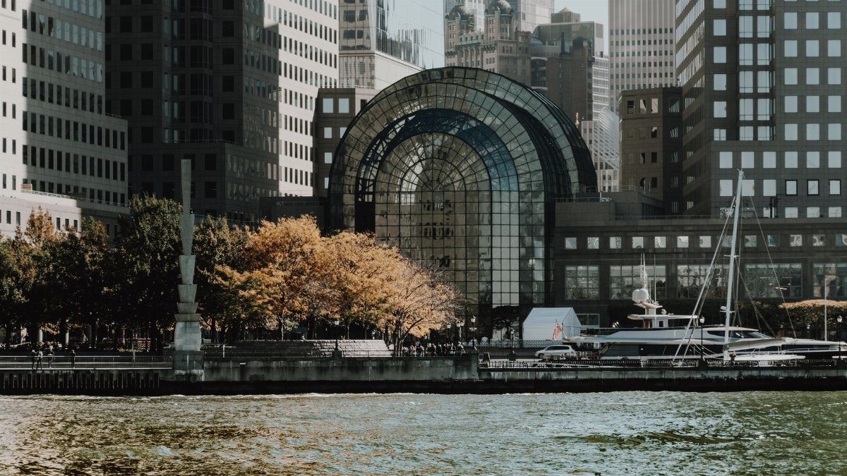 Elegant cityscape featuring modern waterfront buildings and a marina in an urban setting.