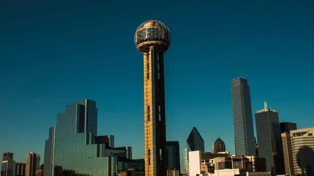 Iconic Dallas skyline with Reunion Tower under a clear blue sky.