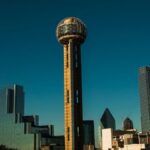 Iconic Dallas skyline with Reunion Tower under a clear blue sky.