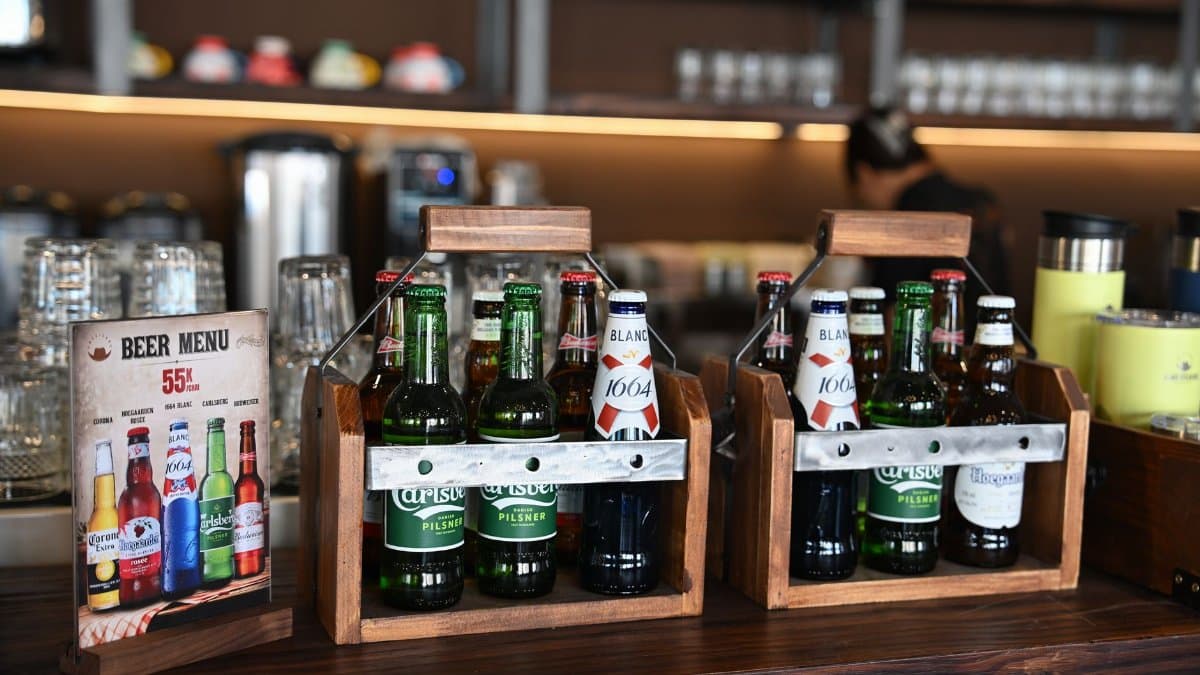 Wooden crate display of craft beers on a bar counter, featuring popular brands.