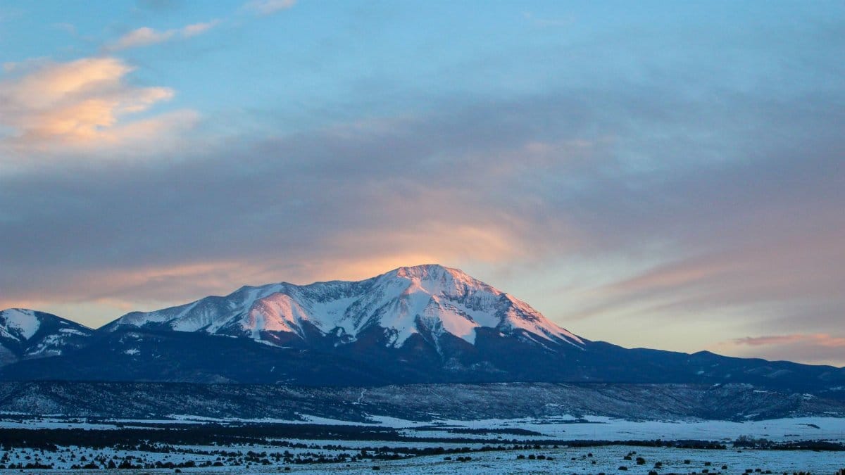 Beautiful winter landscape of Crested Butte, Colorado at sunset with snow-capped mountains.