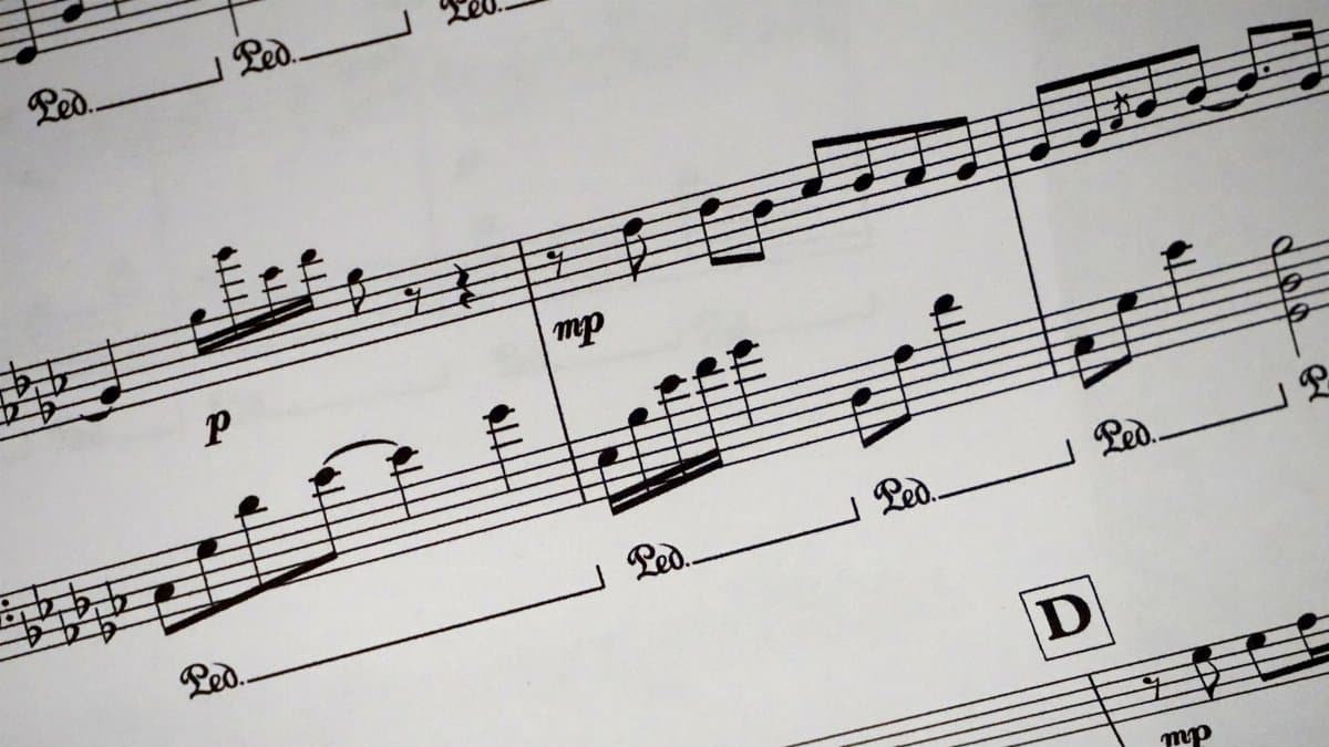 Close-up of a detailed musical sheet showcasing notes and symbols in black and white.