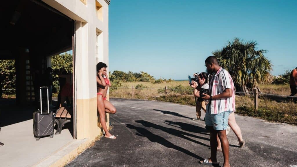A diverse group of photographers capturing a bikini model in an outdoor photoshoot in Miami.