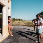 A diverse group of photographers capturing a bikini model in an outdoor photoshoot in Miami.