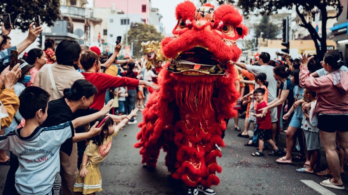 Lion dance performance captivating a lively crowd during the Lunar New Year in Ho Chi Minh City, Vietnam.