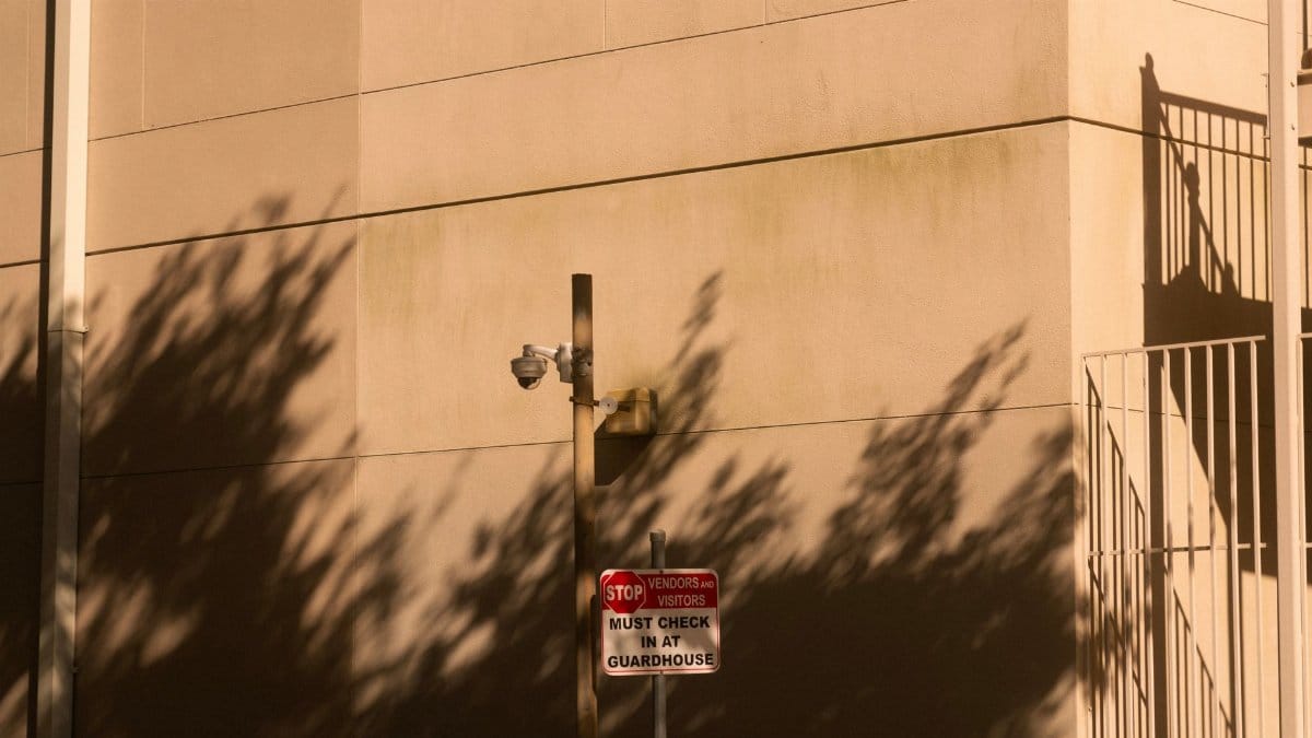 A security camera with shadows on a building wall during sunset in Houston, Texas.