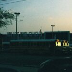 School buses parked near the Dallas Mavericks Arena at dusk, a serene urban scene.