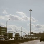 Traffic flows on a Dallas highway under a cloudy sky with visible city skyline. Perfect for urban lifestyle themes.
