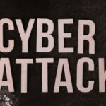 Text 'Cyber Attack' on textured dark paper highlights digital security threat concept.