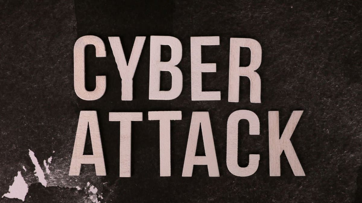Text 'Cyber Attack' on textured dark paper highlights digital security threat concept.