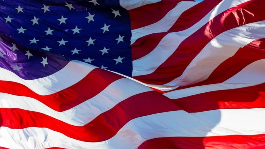 Close-up of the American flag waving majestically in bright sunlight, symbolizing patriotism.