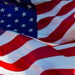 Close-up of the American flag waving majestically in bright sunlight, symbolizing patriotism.