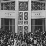 Monochrome image of protesters gathered at Orlando City Hall during a rally.