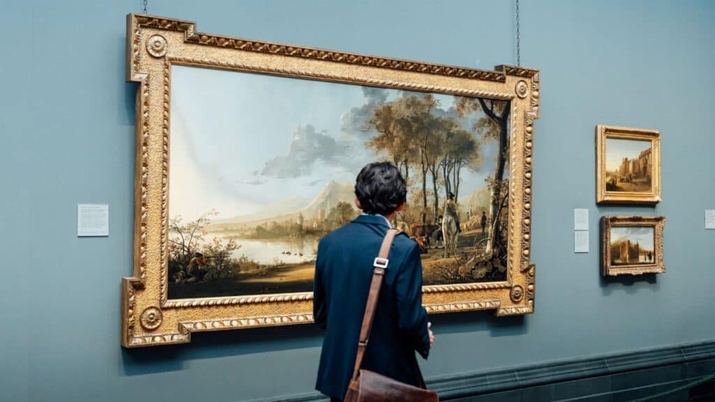 A man admires a large framed painting in an art gallery, England.