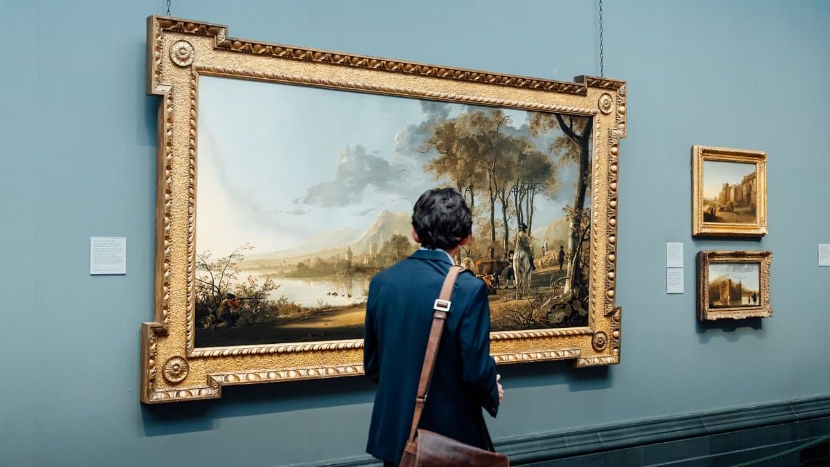 A man admires a large framed painting in an art gallery, England.