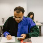 Focused college student with calculator and notes during classroom examination.