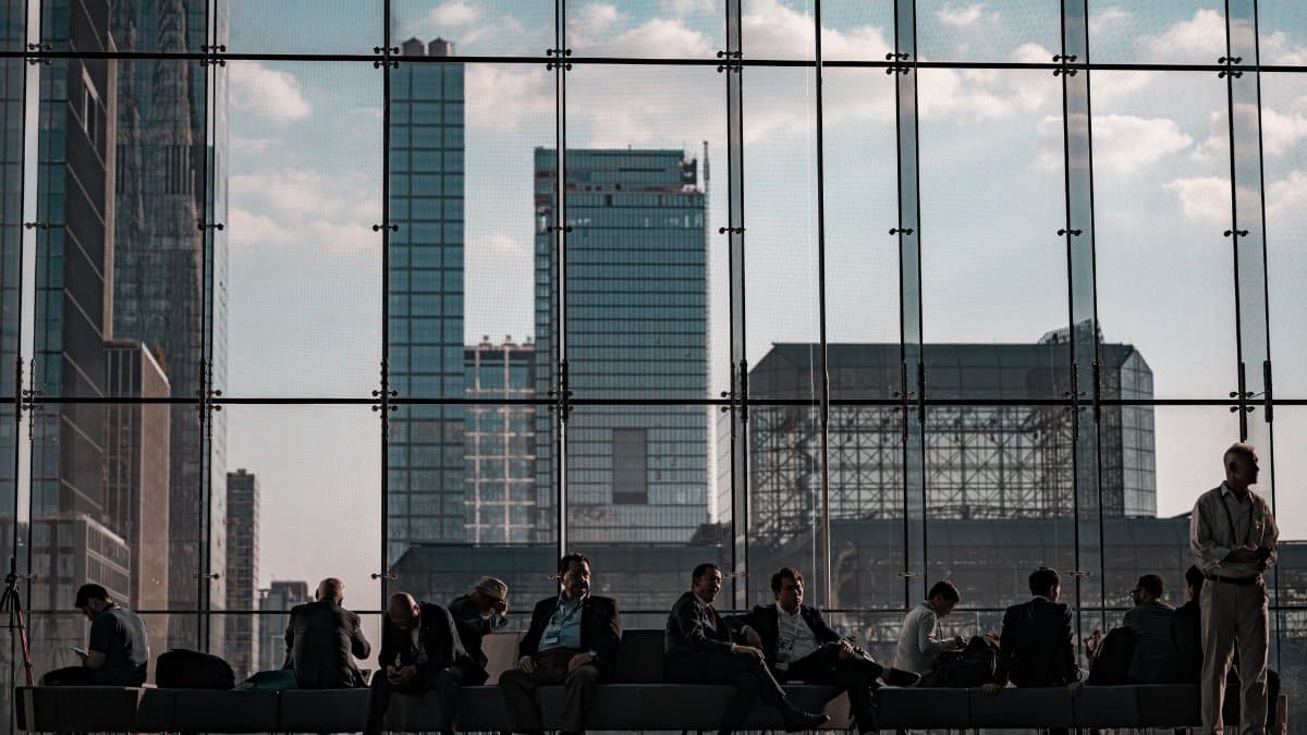 Business professionals at the Javits Center, New York City featuring urban skyline through glass facade.