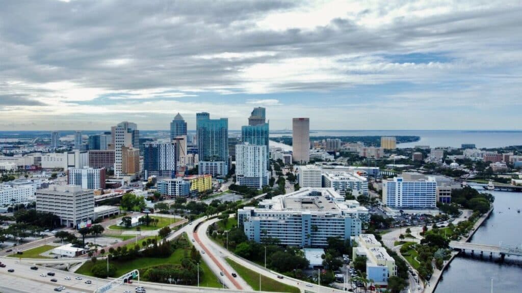 A stunning aerial view of Tampa, FL cityscape featuring modern skyscrapers against clouded skies.