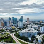A stunning aerial view of Tampa, FL cityscape featuring modern skyscrapers against clouded skies.