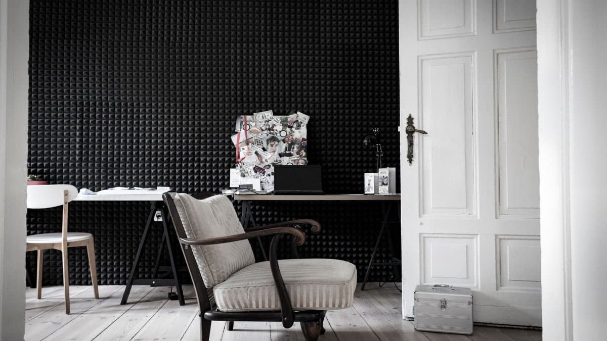 A stylish home study featuring modern design, acoustic walls, and elegant seating arrangement.