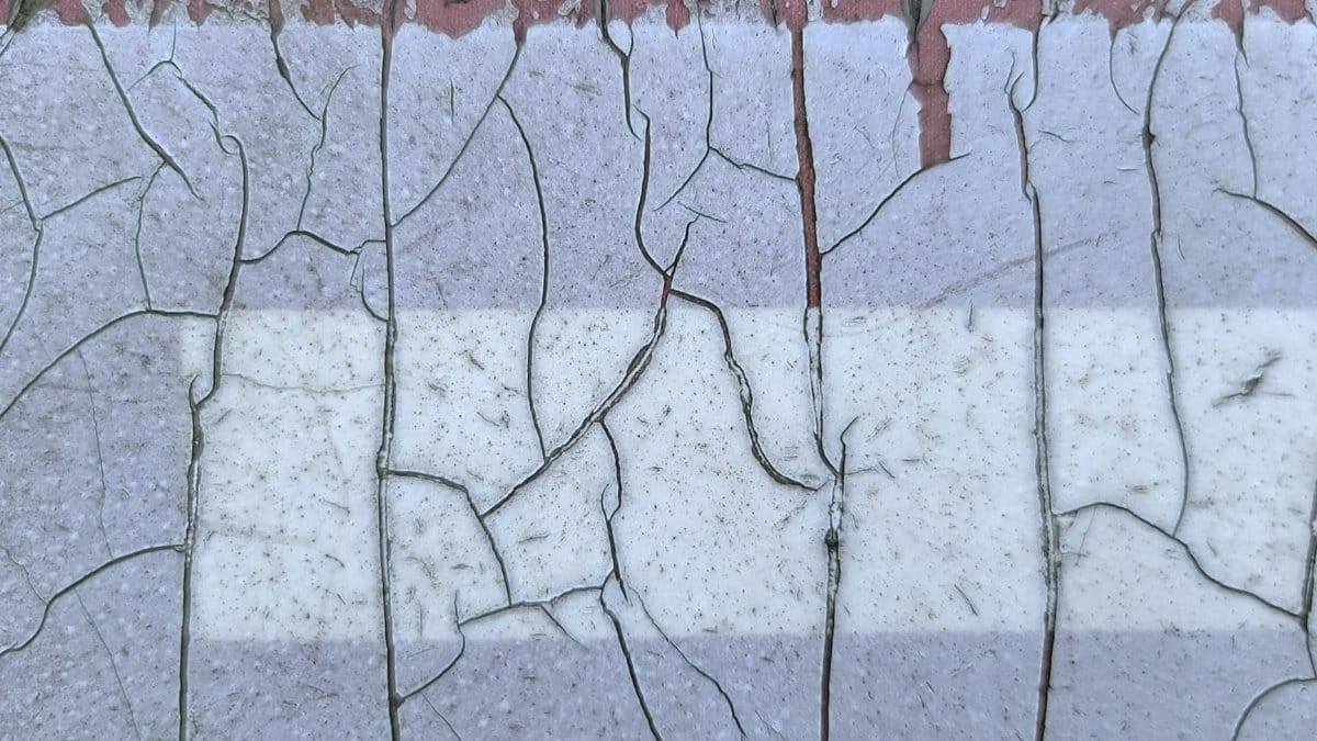 A close-up of a cracked and weathered painted wall in New Taipei City, Taiwan.