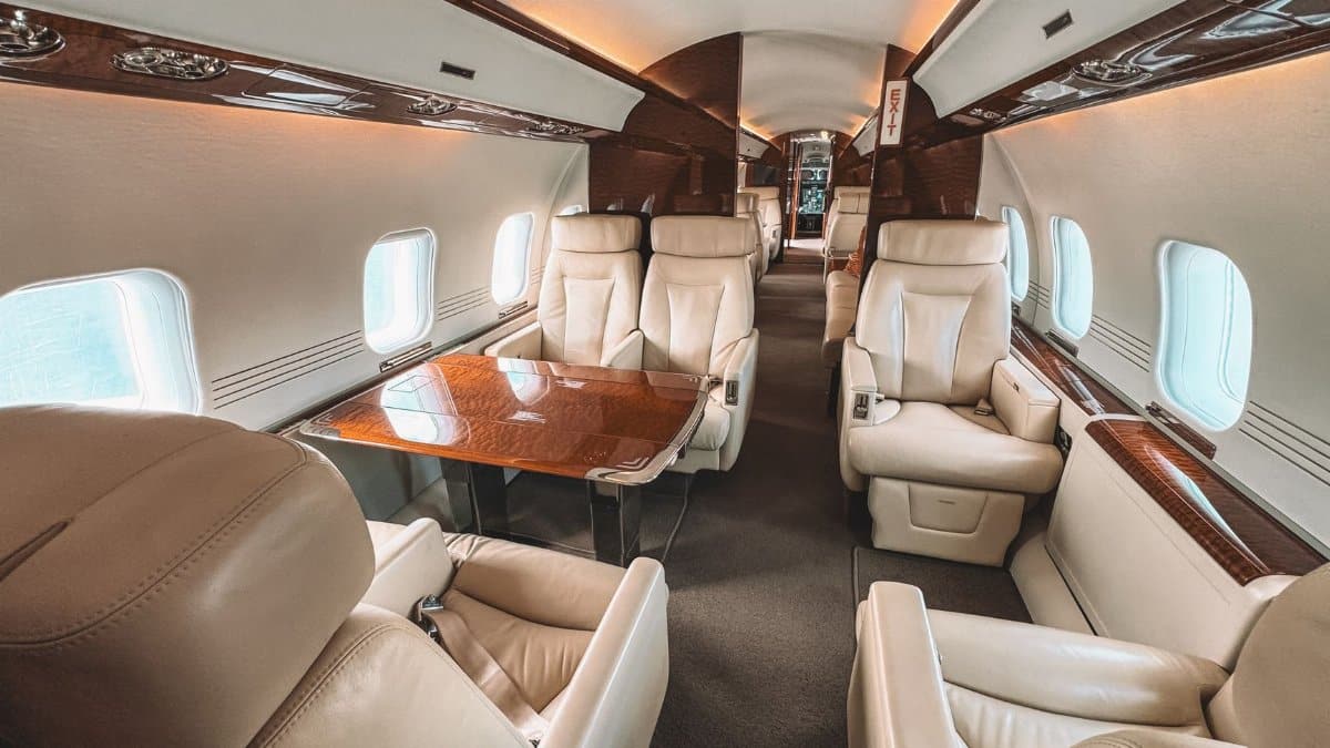 Luxurious interior of a private jet showcasing leather seating and elegant wooden trim.