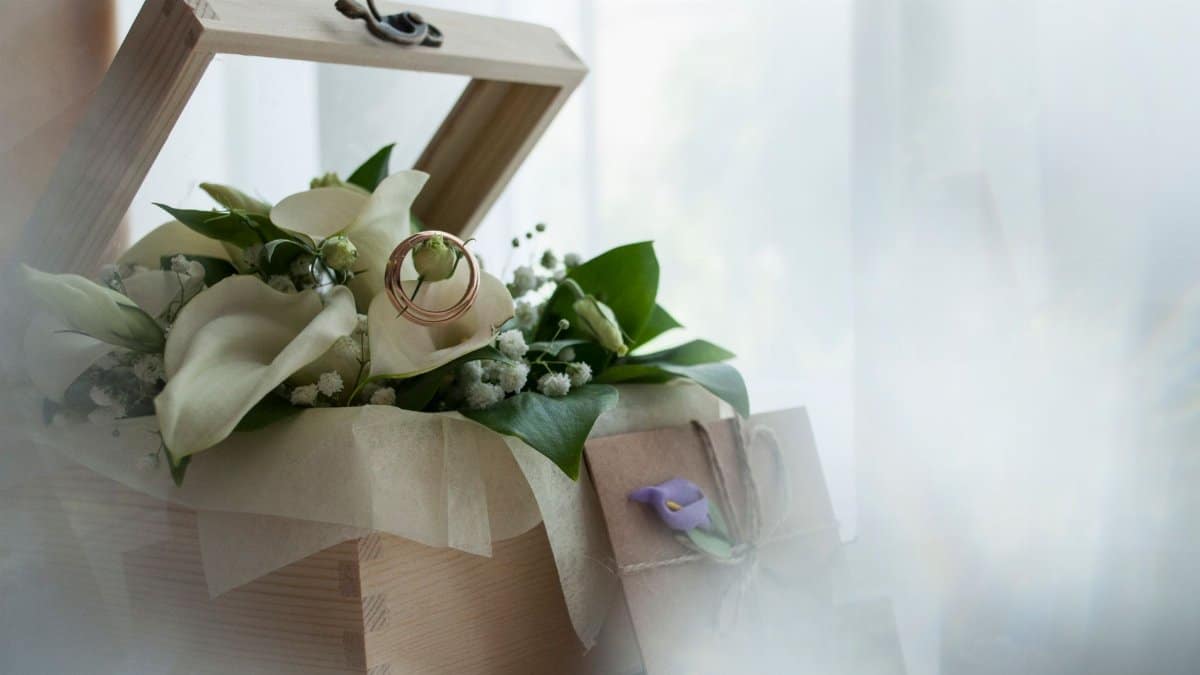 Beautiful wedding bouquet with rings in a rustic gift box, perfect for romantic celebrations.