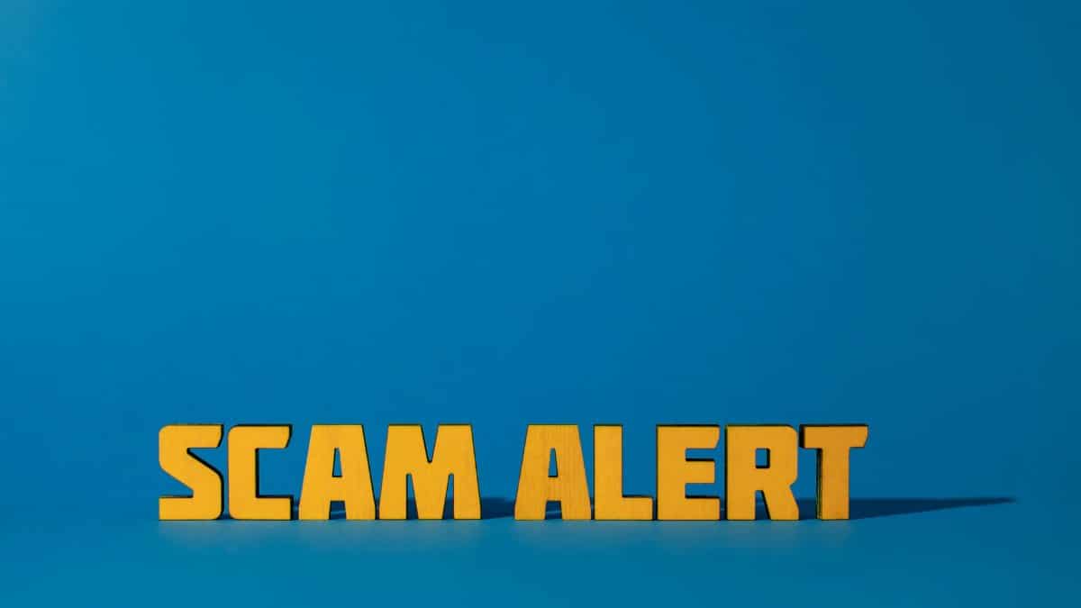 Bold yellow 'Scam Alert' text on a vivid blue surface, emphasizing warning and caution.