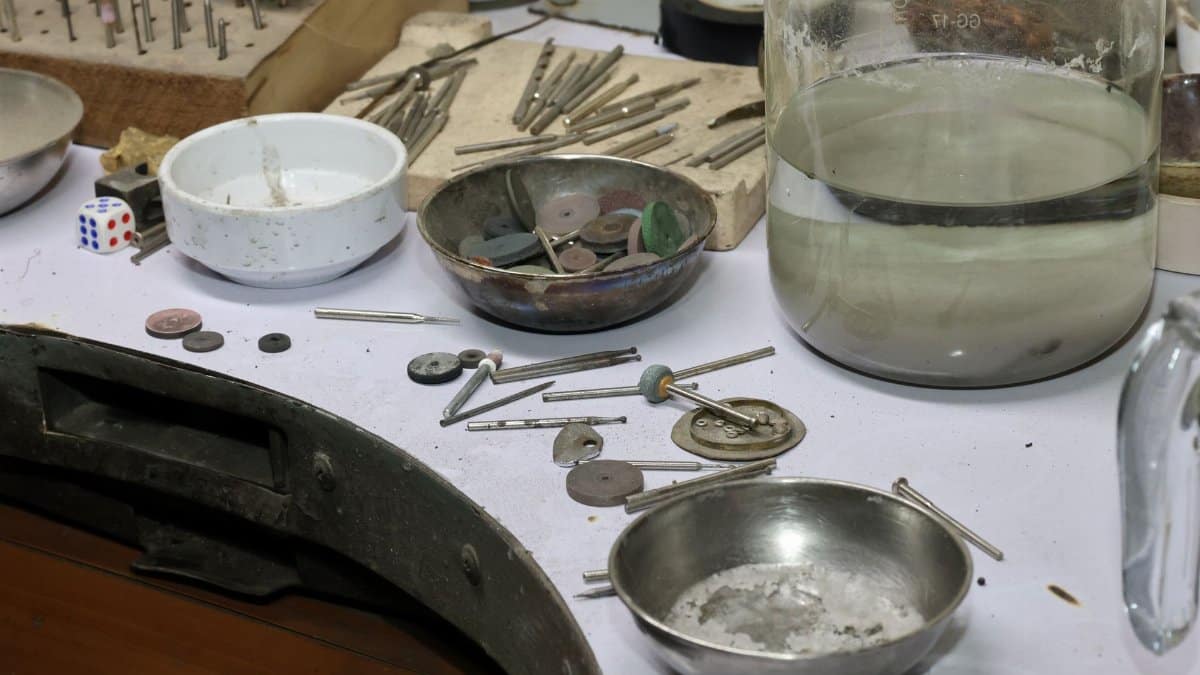 A detailed view of a jeweler's workbench with various tools and materials for crafting and repair.