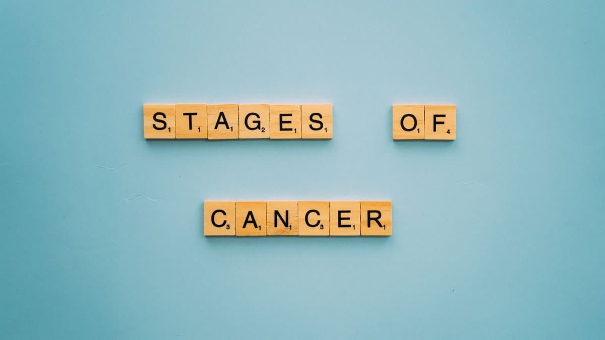 Wooden tiles on a blue background forming the words 'Stages of Cancer'.